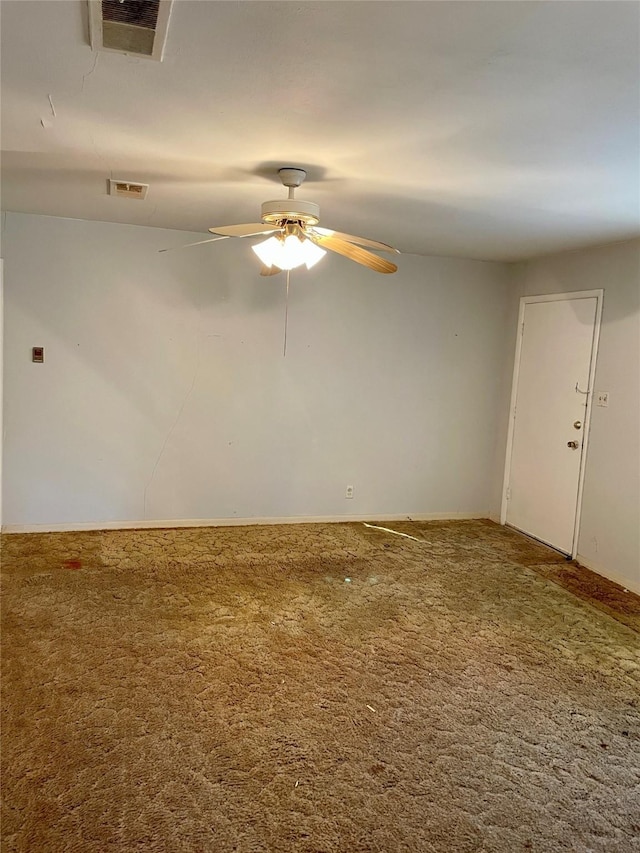 carpeted spare room featuring visible vents and a ceiling fan