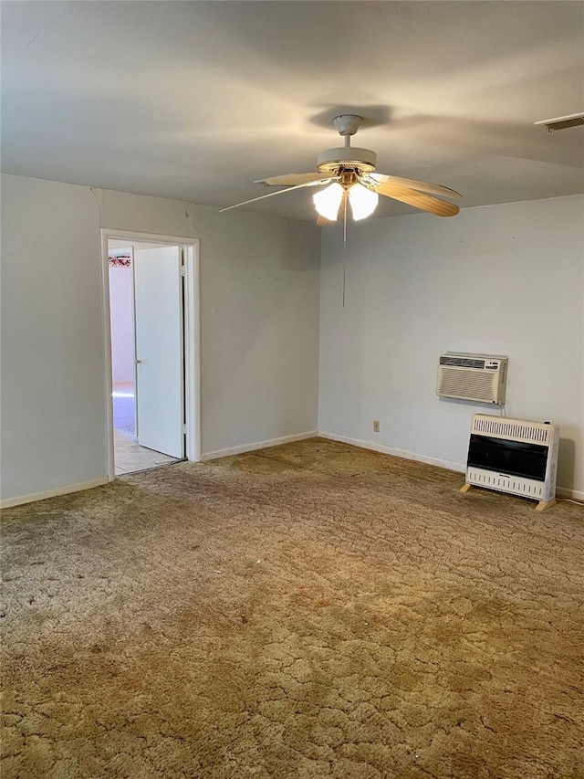 carpeted spare room featuring baseboards, a wall mounted air conditioner, a ceiling fan, and heating unit