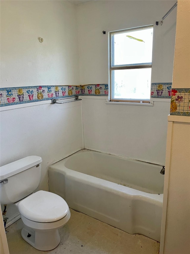 bathroom featuring toilet, a wainscoted wall, and a bath