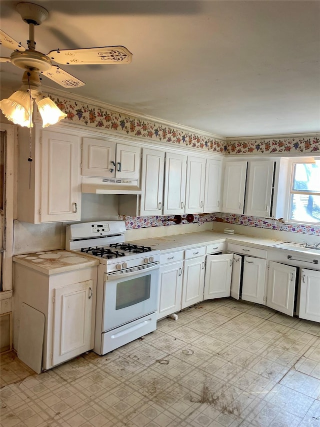 kitchen with light countertops, white range with gas cooktop, under cabinet range hood, and light floors