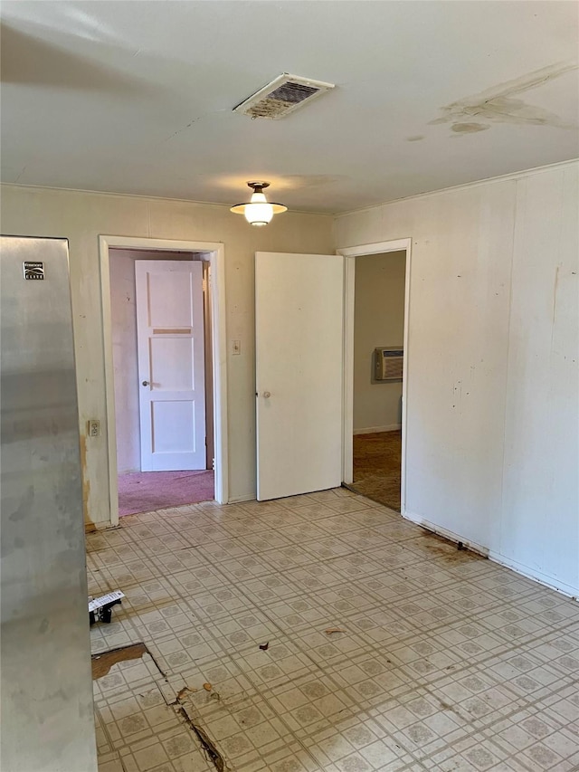 empty room with a wall unit AC and visible vents