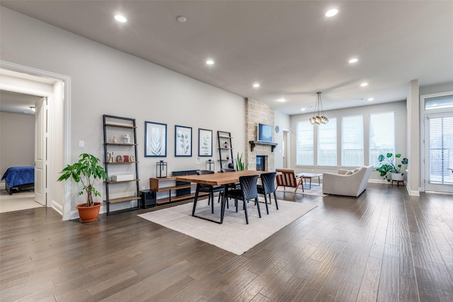 dining room featuring dark wood-style floors, a fireplace, and recessed lighting