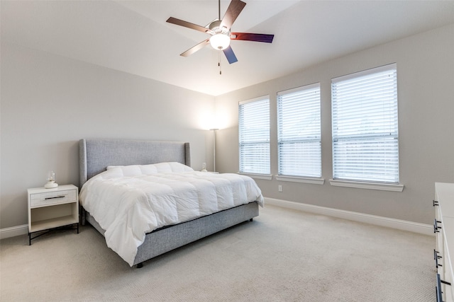 bedroom with light carpet, ceiling fan, and baseboards