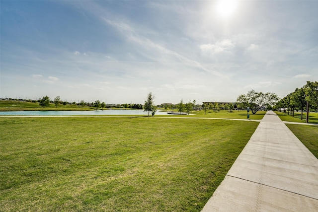 surrounding community featuring a water view and a lawn