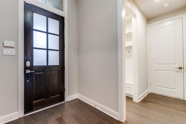 foyer with baseboards and dark wood finished floors