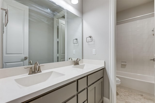 bathroom featuring double vanity, shower / tub combination, a sink, and toilet