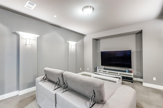 carpeted cinema room featuring visible vents and baseboards