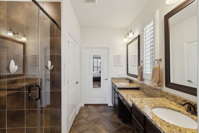 bathroom with double vanity, a stall shower, a sink, and visible vents