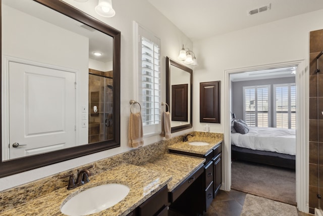 bathroom featuring double vanity, a stall shower, a sink, and visible vents