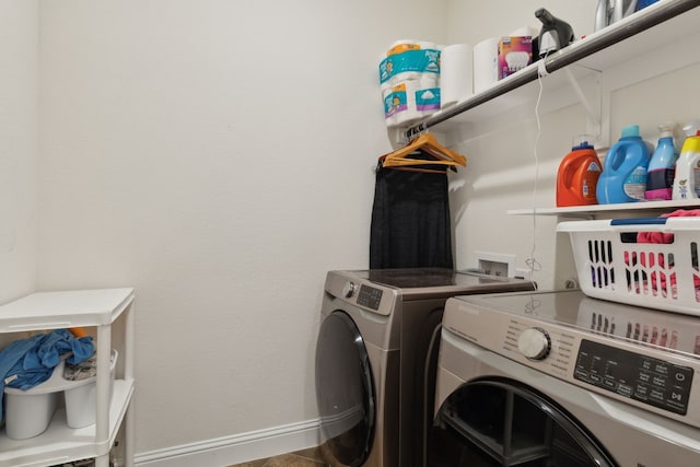 washroom featuring laundry area, washing machine and dryer, and baseboards