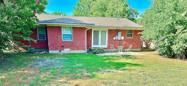 view of front of property featuring entry steps, brick siding, a patio, and a front lawn