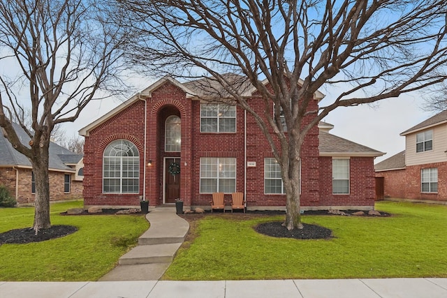 traditional home with brick siding and a front lawn