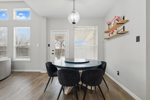 dining space with baseboards and wood finished floors