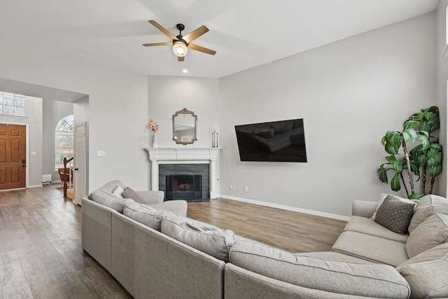 living room featuring baseboards, wood finished floors, and a tile fireplace