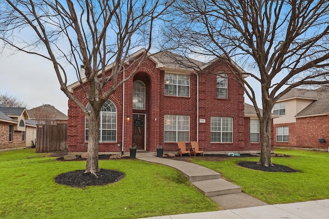 traditional-style home featuring brick siding and a front lawn