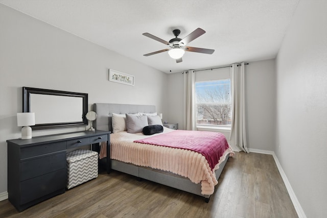 bedroom with ceiling fan, wood finished floors, and baseboards