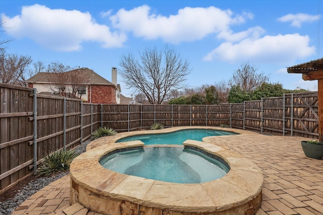 view of swimming pool featuring an in ground hot tub, a patio, and a fenced backyard