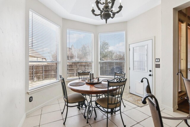 dining room with a chandelier, light tile patterned floors, and baseboards