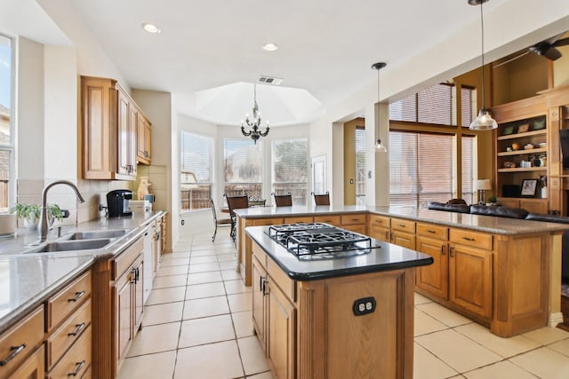 kitchen with gas cooktop, a kitchen island, a sink, and light tile patterned floors