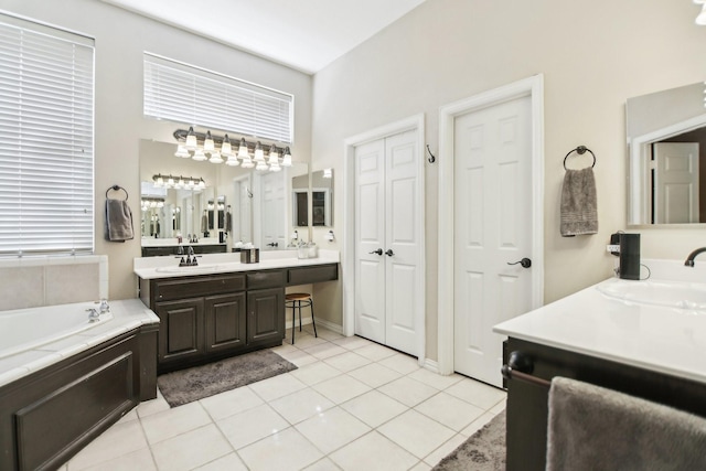 full bathroom with a garden tub, two vanities, a sink, and tile patterned floors