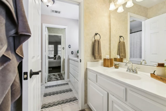 ensuite bathroom with visible vents, connected bathroom, and vanity