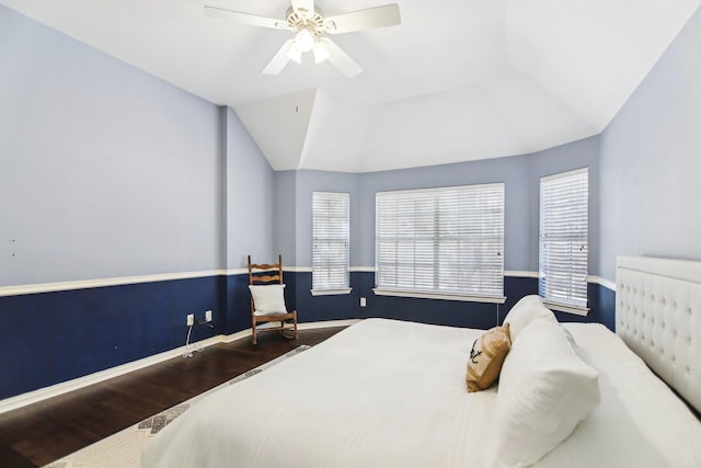 bedroom with a ceiling fan, vaulted ceiling, baseboards, and wood finished floors