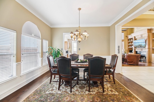 dining room featuring an inviting chandelier, crown molding, and wood finished floors