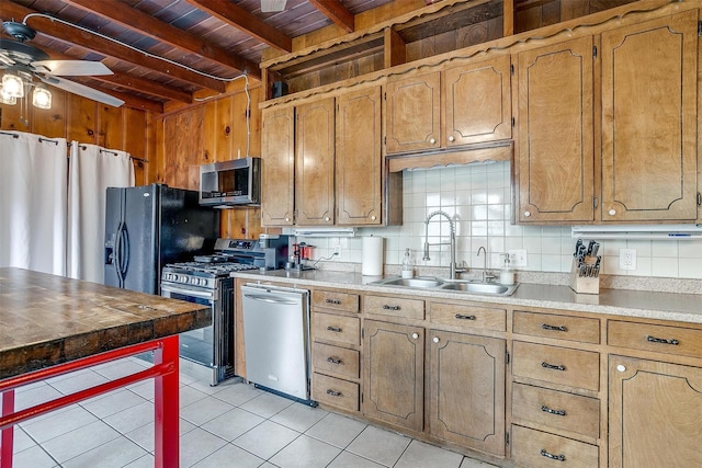 kitchen with stainless steel appliances, a sink, light countertops, beam ceiling, and tasteful backsplash