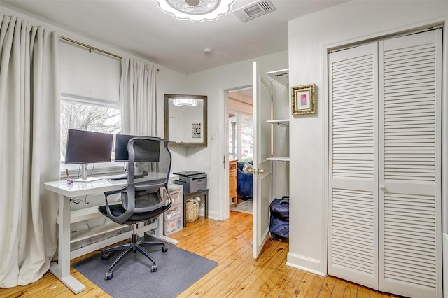 home office with visible vents, baseboards, and hardwood / wood-style flooring