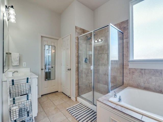 bathroom featuring a stall shower, vanity, a bath, and tile patterned floors