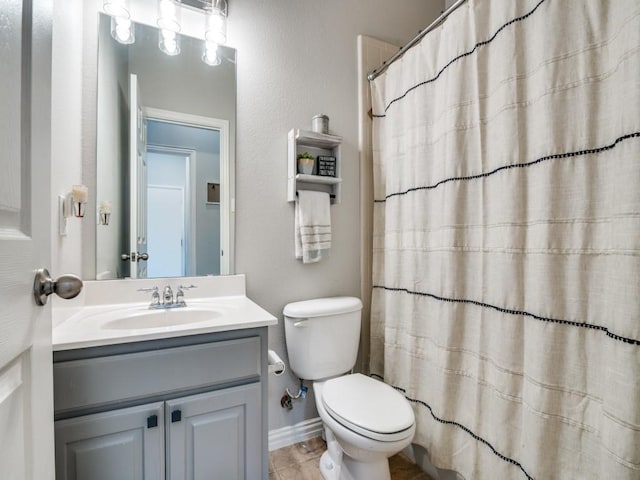 bathroom featuring toilet, baseboards, a shower with shower curtain, and vanity