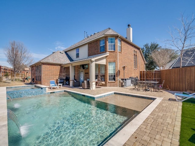 view of swimming pool with outdoor dining area, a patio area, a pool with connected hot tub, and a fenced backyard