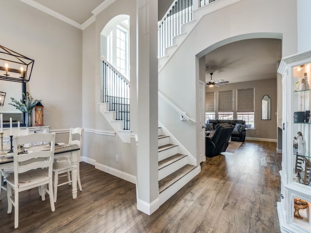 stairway with baseboards, arched walkways, hardwood / wood-style floors, and ornamental molding