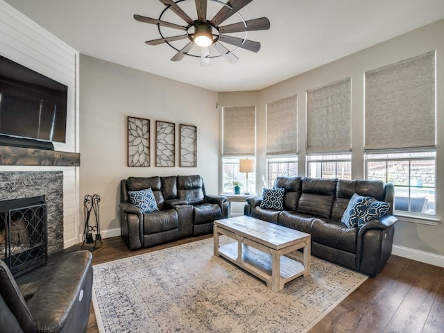 living area featuring dark wood-type flooring, plenty of natural light, and a fireplace