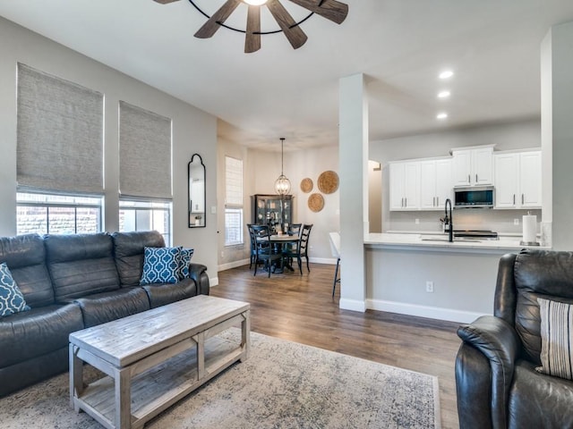 living room with dark wood-style floors, baseboards, a ceiling fan, and recessed lighting