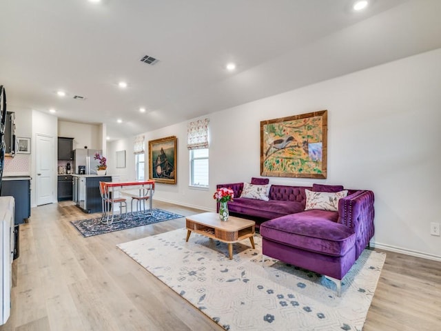 living room featuring light wood-style floors, recessed lighting, visible vents, and baseboards