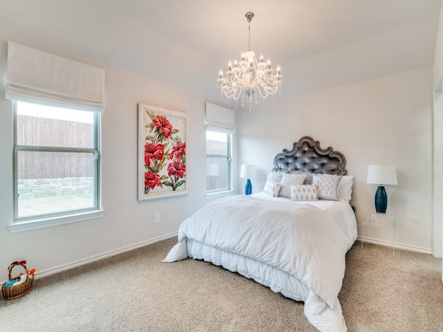 bedroom featuring a chandelier, carpet floors, multiple windows, and baseboards