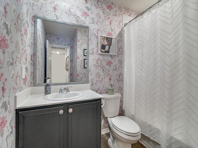 bathroom featuring wallpapered walls, toilet, a shower with curtain, wood finished floors, and vanity