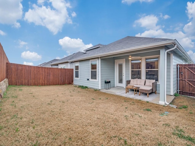 rear view of property with a patio, a yard, a fenced backyard, and an outdoor living space