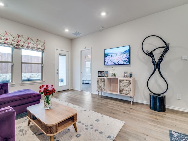 living room with light wood-style floors, visible vents, baseboards, and recessed lighting