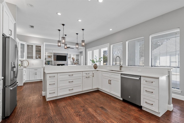 kitchen with light countertops, appliances with stainless steel finishes, dark wood-style flooring, and a sink