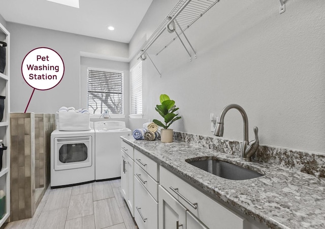 laundry room featuring independent washer and dryer, a sink, and cabinet space