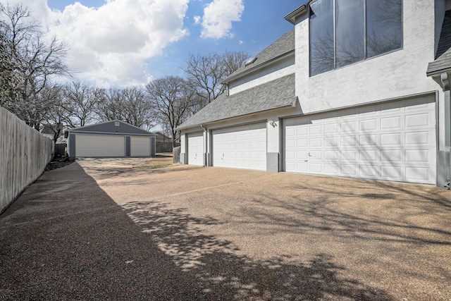 garage with driveway and fence