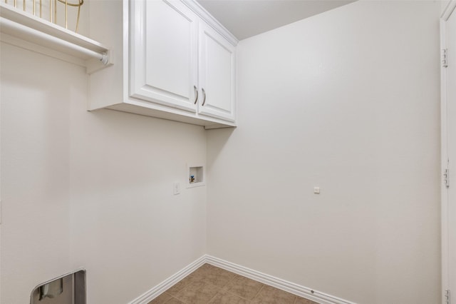 washroom featuring hookup for a washing machine, cabinet space, and baseboards