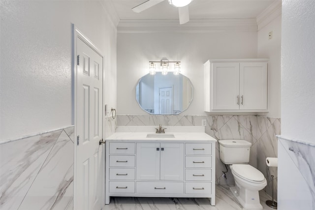 bathroom featuring wainscoting, toilet, ornamental molding, marble finish floor, and vanity