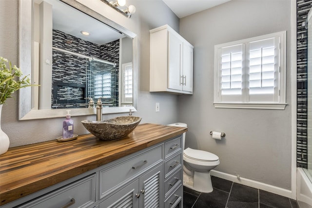 full bath with toilet, shower / bath combination, vanity, baseboards, and tile patterned floors