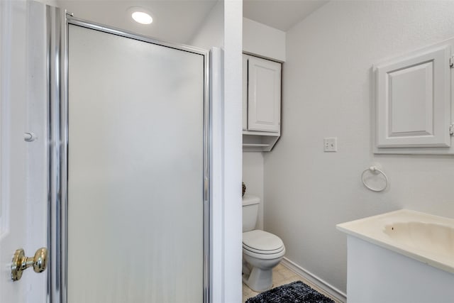 full bathroom featuring tile patterned flooring, toilet, vanity, baseboards, and a shower stall