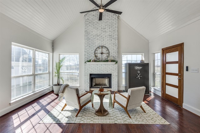 interior space featuring high vaulted ceiling, a wealth of natural light, a brick fireplace, and hardwood / wood-style flooring