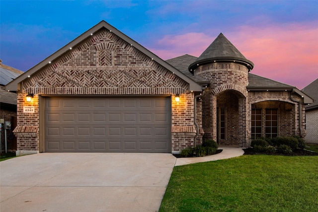 french country inspired facade with a garage, driveway, brick siding, and a front yard