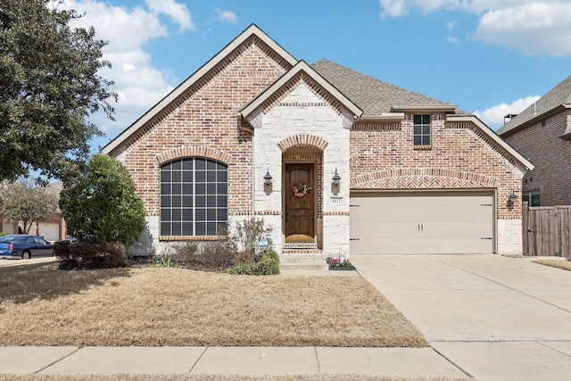 french provincial home featuring stone siding, brick siding, roof with shingles, and an attached garage